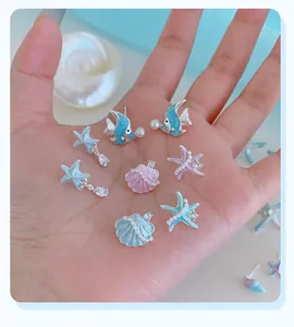 Dettaglio orecchini stile marino color pastello con stelle marine, perle e smalto