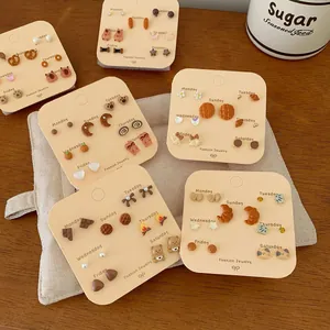 Set of 7 pairs of autumn tortoise shell bear and bread studs on a weekly display card