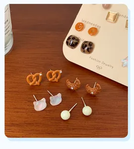 Detailed set of cute resin dessert earrings with pretzel and croissant shapes