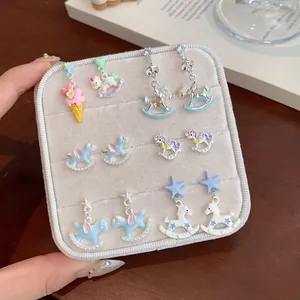 Cartoon carousel unicorn earring set with colorful enamel charms on display board