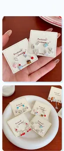 Detailed macro shot of dopamine-style cherry and cupcake enamel stud earrings set