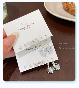 Detailed view of silver zircon star and heart earring set on display cards