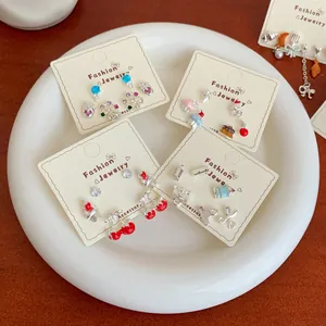 Colorful dopamine-style cherry and cupcake earring set on elegant display card