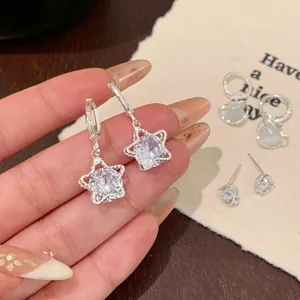 Elegant silver star and heart earring set with sparkling cubic zirconia on a warm background