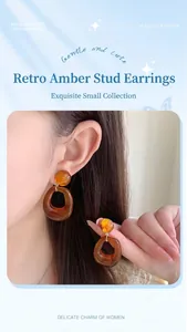 Close-up of vintage amber resin hoop earrings worn by a model in soft lighting