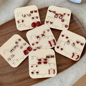 Rode emaille oorknopjes set voor één week, hart- en beerontwerpen op houten blad