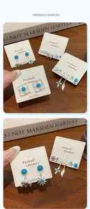 Macro shot of silver bohemian earrings set with turquoise sun and elephant motifs