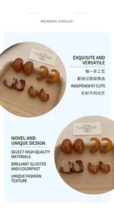Detailed close-up of amber resin earrings in irregular shapes on a kraft tray