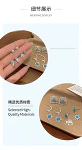Detail view of Bohemian silver stud earring set featuring blue stones and celestial icons