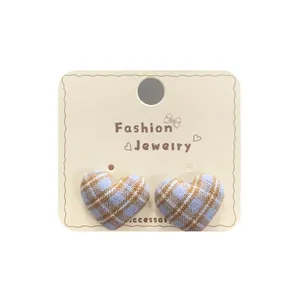 Vintage checkered heart studs in blue and brown fabric on jewelry card display