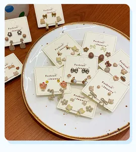 Detailed set of cute cartoon bear and cat stud earrings in warm brown and beige tones