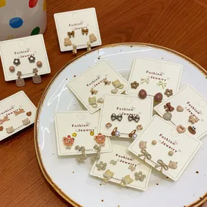 Cute panda and cat earring set in brown tones on a decorative white ceramic plate