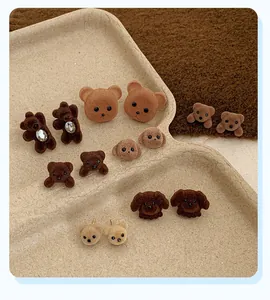 Detailed view of flocked teddy bear stud earrings with crystal accents and soft texture
