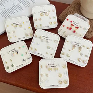 Golden stud earring set with cute panda and strawberry designs on 7 display cards