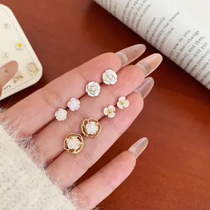 French vintage gold flower stud earring set featuring roses and pearls on hands