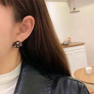 Vintage geometric heart pattern square earrings worn by model for fashion display