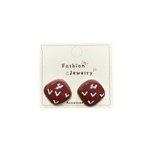 Retro deep red square heart stud earrings with white pattern on a jewelry display card
