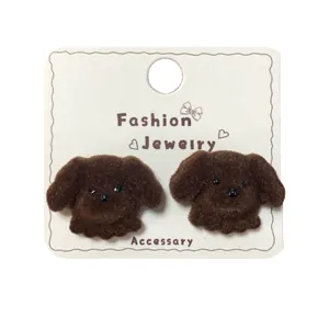 Cute brown flocked teddy bear stud earrings with fuzzy texture on a display card