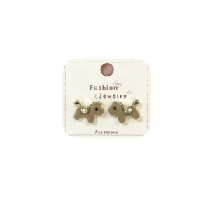 Brown flocked puppy earrings with gold accents on display card, festive accessories