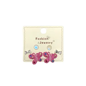 Pink Barbie style butterfly earring set with colorful crystals and pearl studs on card
