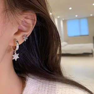 Sparkling silver snowflake stud earring set with cubic zirconia on a female model