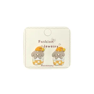 Cute cartoon puppy earrings with yellow nightcap design on white jewelry card