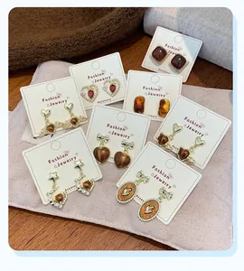 Detailed close-up of vintage Maillard style amber and tiger eye earrings with gold finish