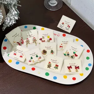 Christmas earring set with festive snowman, Santa and tree designs on white display card