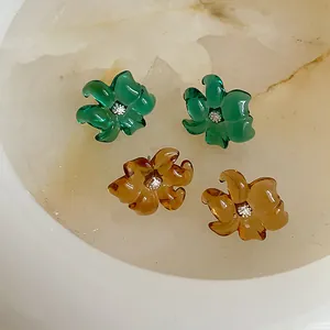 Pendientes de flores de resina de colores con cristales brillantes sobre mármol