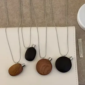 Collier avec pendentif flacon de parfum vintage en bois et chaîne en métal argenté