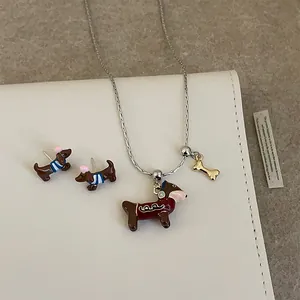 Détail d'une parure de bijoux teckel avec breloques en émail et pendentif os