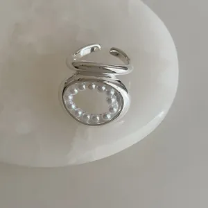 Gros plan détaillé de la bague argentée avec design ovale évidé et incrustation de perles