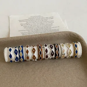 Macro view of vintage enamel rhombus pattern rings in assorted colors on a display stand