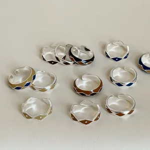 Macro detail of colorful enamel diamond patterns on adjustable silver geometric rings