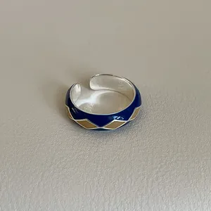 Detailed macro shot of vintage enamel diamond pattern on a silver adjustable open ring
