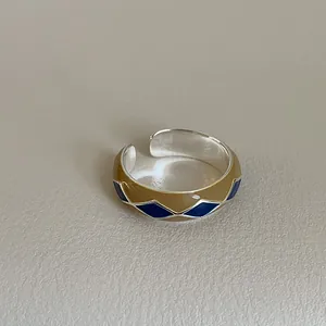 Macro detail of retro enamel diamond patterns on adjustable silver geometric ring