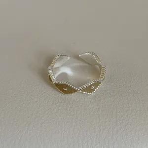 Close-up of vintage silver ring with amber enamel rhumb pattern and beaded edges