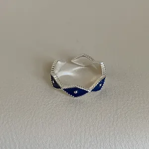 Close-up of blue enamel diamond patterns and silver bead textures on adjustable ring