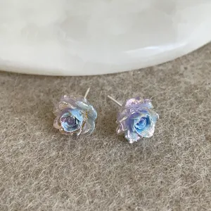Macro detail of rose earrings with purple blue gradient and shimmering pearlescent finish
