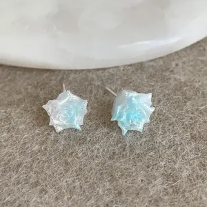 Macro shot of blue gradient rose resin stud earrings with a subtle pearlescent shimmer