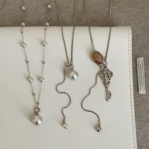 Tres elegantes collares de plata vintage con perlas, colgante de llave y piedras brutas