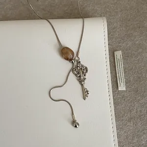 Collar de cadena de serpiente plateada con colgante llave café y cuenta de ámbar