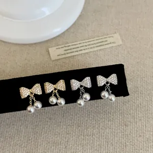 Elegante strikparel oorbellen in goud en zilver met pavé gezette kristallen