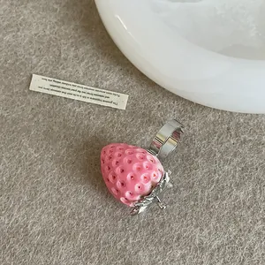 Detalle macro de un anillo de fresa rosa con textura de resina y banda plateada dulce