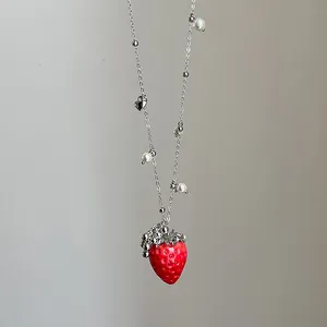 Detailansicht der realistischen Erdbeerkette mit Perlen und Herzanhänger in Makro