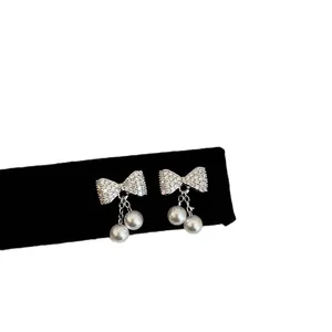 Elegante strik oorbellen met zirkonia en parels in zilveren afwerking, luxe modegoed