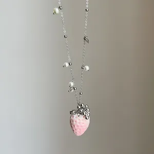 Nahaufnahme der rosa beflockten Erdbeer-Halskette mit weißen Perlen und Silberkette