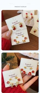 Detail of red and gold Chinese knot earrings with lucky cat and fortune motifs