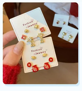 Close-up of festive red Chinese knot earrings with Lucky Cat and Fortune motifs