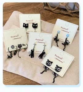 Detailed display of black cat earrings set with stars and fish on display cards